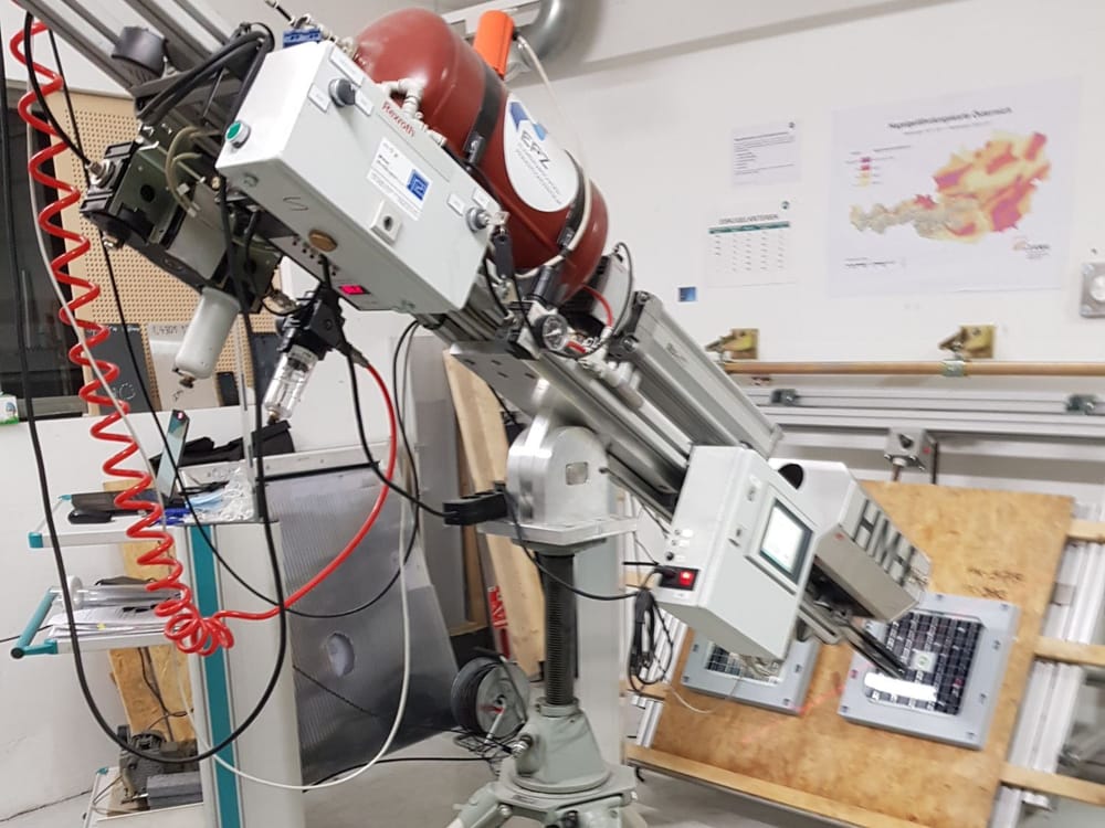 The IBS Hail Lab's compressed-air ice launcher on its tripod, barrel aimed at Tessera sensors on the target board