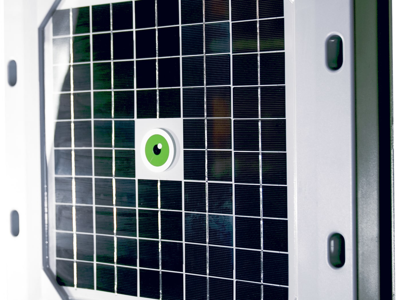 Angled close-up of a Tessera sensor: the solar panel that doubles as the impact collection surface, with the green Hailios eye at its center